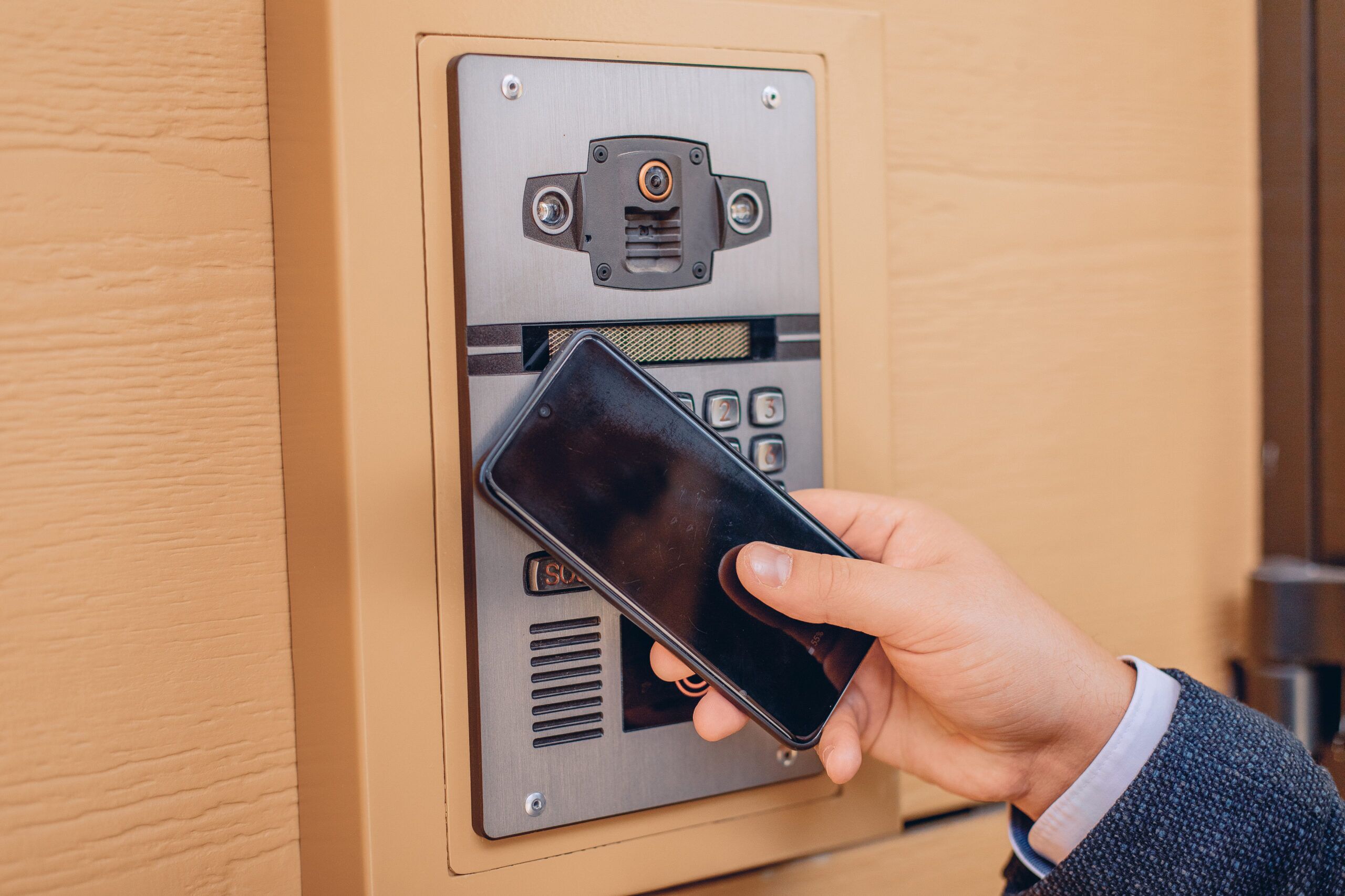innovative technologies close up smart intercom with video camera man s hand holds phone him scaled